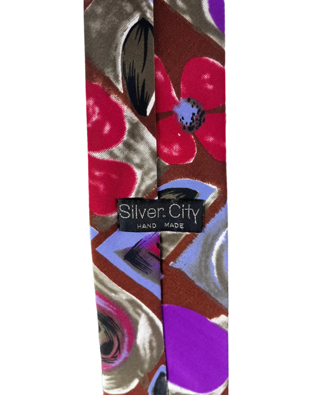Colorful floral-patterned tie with 'Silver City' label on a mannequin against a white brick wall.