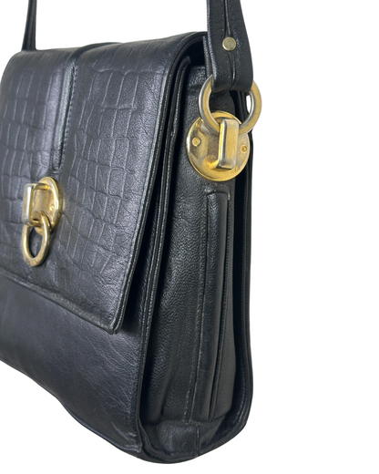 Black leather handbag with gold hardware on a white background