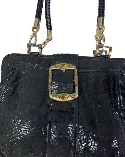 Black textured handbag with gold buckle and strap on a white background