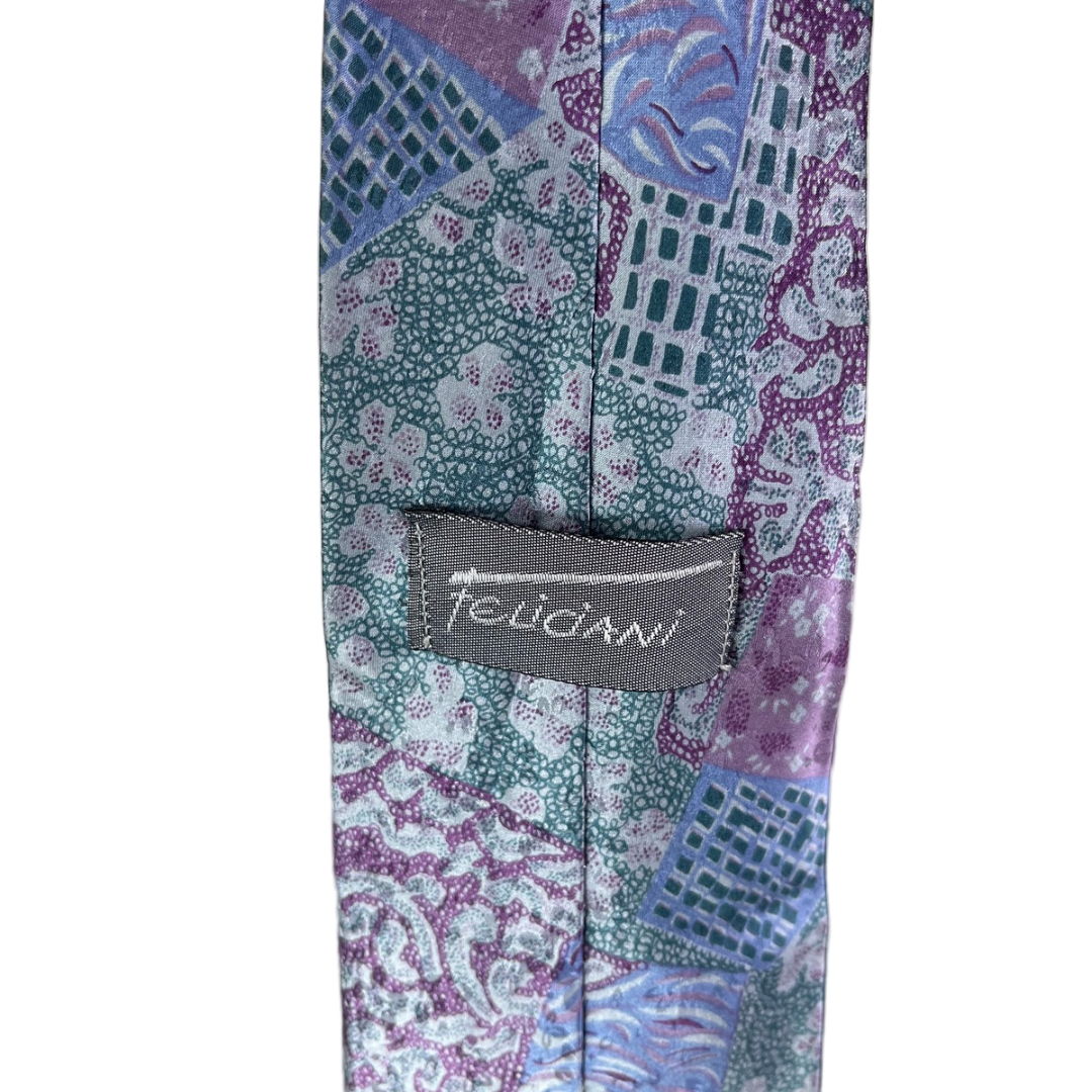 Patterned tie with a brand label on a neutral background