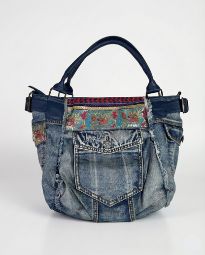 Denim handbag with floral patterned strap on a white background
