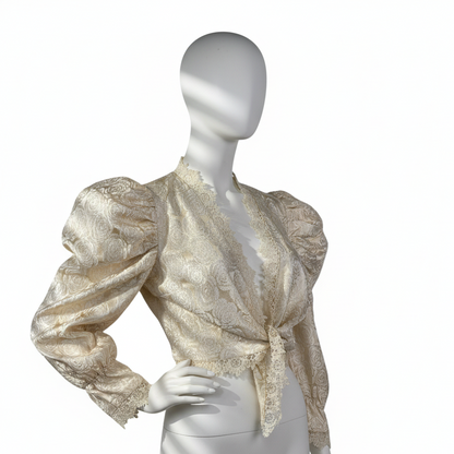 Mannequin wearing a gold and white patterned blouse on a white background