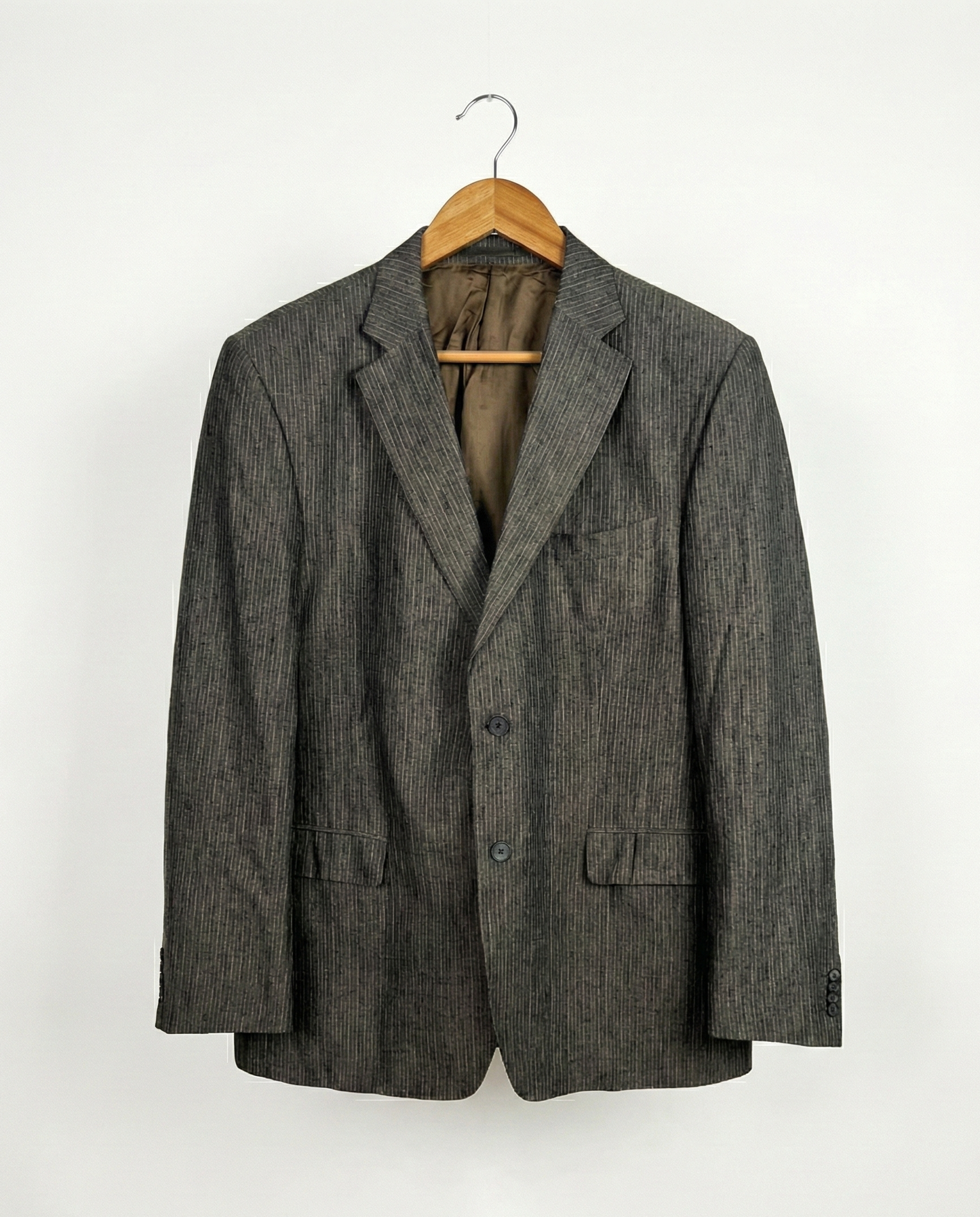 Gray blazer on a hanger against a white background