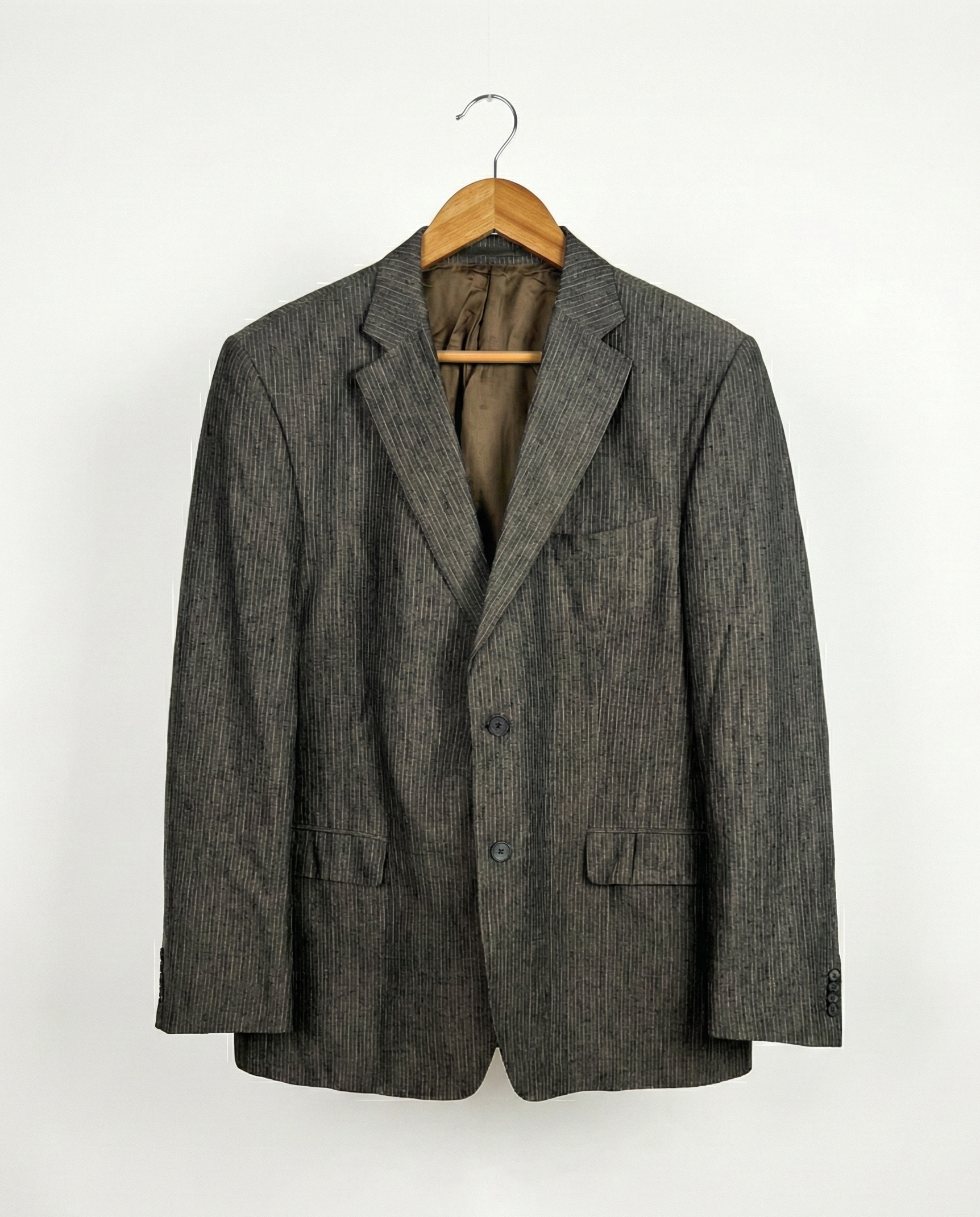 Gray blazer on a hanger against a white background